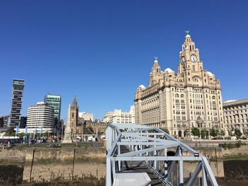 Buildings in city against blue sky