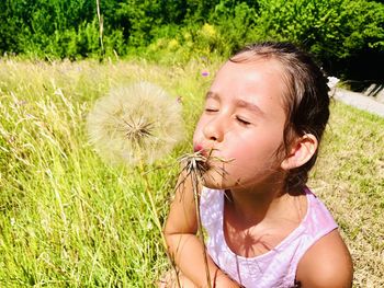 Girl looking away while standing on grassy field