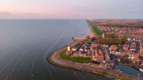 High angle view of city by sea against sky