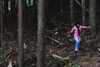 Woman walking on field in forest