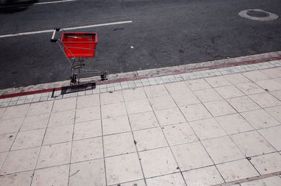 Red shopping cart on side walk