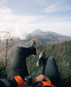 Rear view of man on volcanic mountain against sky