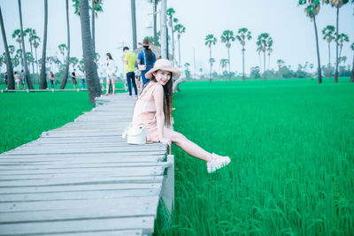 Full length portrait of woman sitting on land