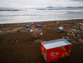 Garbage on sand at beach against sky