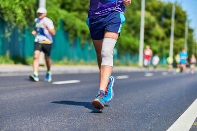 Low section of man running on road