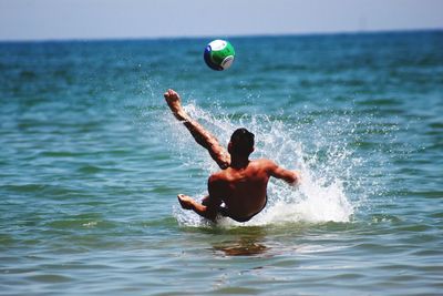 Rear view of shirtless man in sea