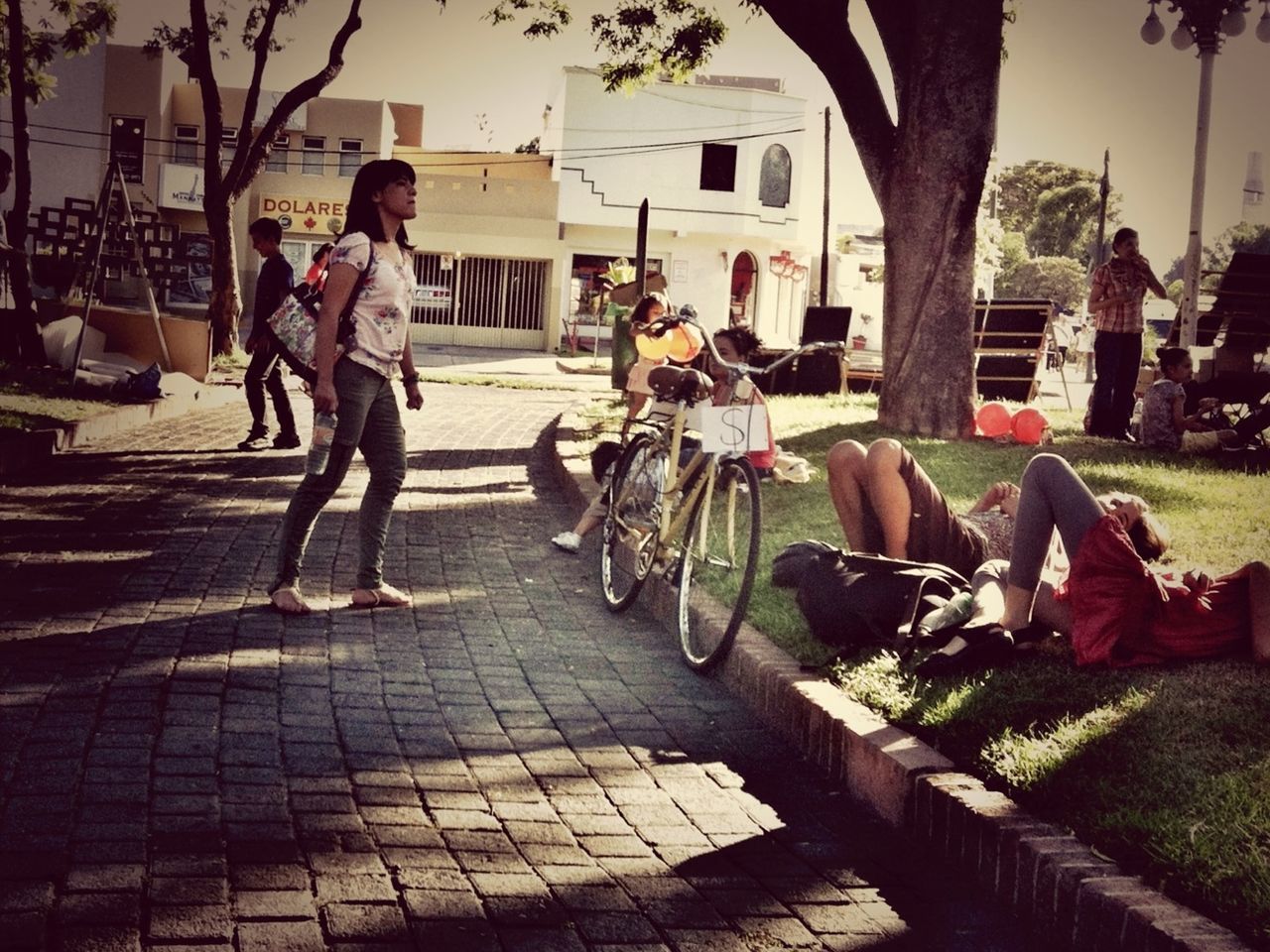 lifestyles, men, person, leisure activity, building exterior, sitting, architecture, tree, built structure, large group of people, togetherness, full length, bicycle, casual clothing, street, city life, city, medium group of people