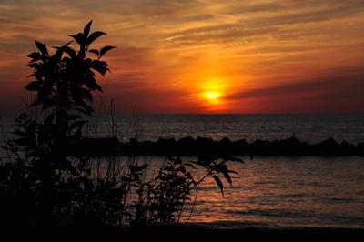 Scenic view of sea against romantic sky at sunset