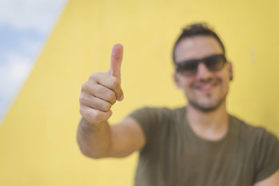 Portrait of smiling man gesturing thumbs up