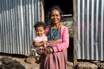 Portrait of a smiling girl standing against building