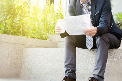 Low section of man reading book