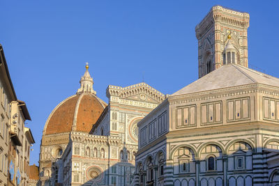 Low angle view of buildings against clear blue sky