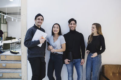 Portrait of four happy people in creative office