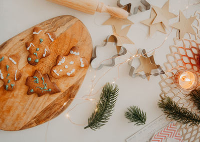  home-made cookie form of  christmas tree, snowflakes in plate on  table with candle, christmas tree