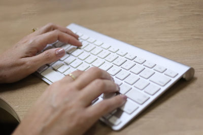 Midsection of person using laptop on table