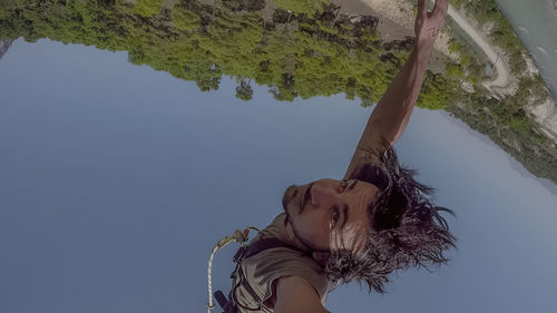 Portrait of woman by tree against sky