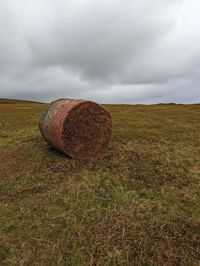 Hay bales on field against sky