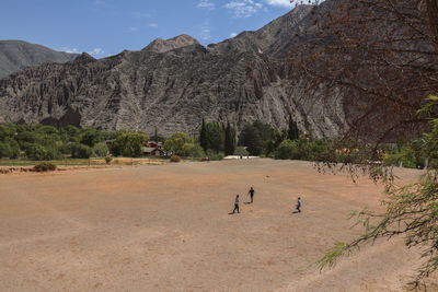 Group of people on landscape against mountain range