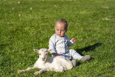 Boy with dog sitting on grass