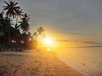 Scenic view of beach against sky during sunset