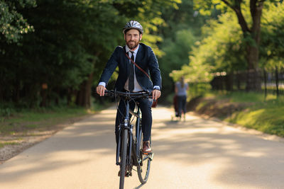 Young man riding bicycle on road