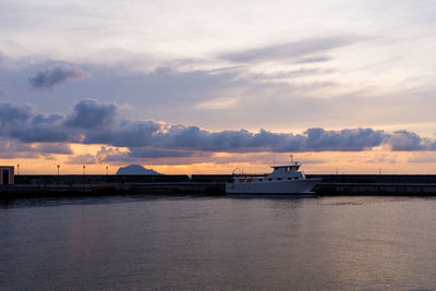 Silhouette boat sailing in sea against sky during sunset