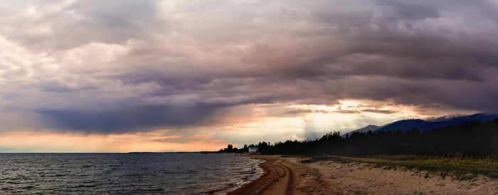 Scenic view of sea against dramatic sky during sunset