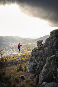 Woman with arms raised highlining in mountains at baden-baden, germany