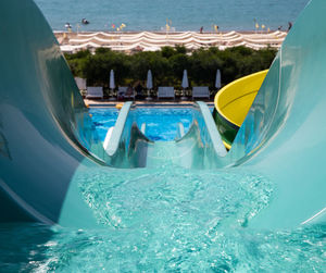 Swimming pool by sea against sky