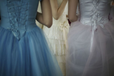 Midsection of women in evening gown at party