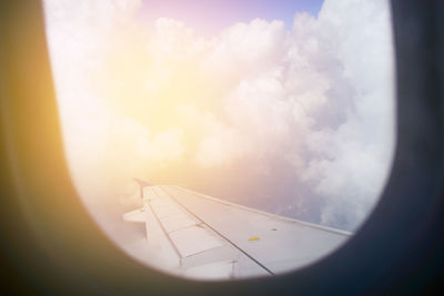 Airplane flying against sky seen through window