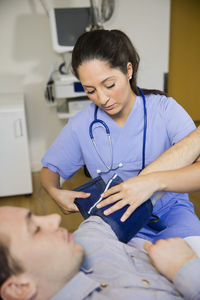 Doctor checking patients blood pressure