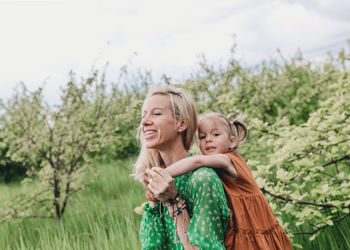 Portrait of mother and daughter against plants