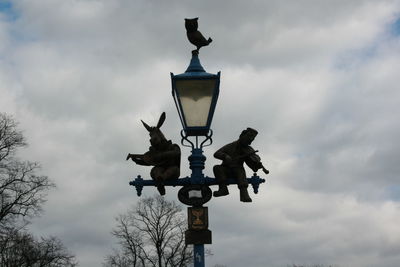 Low angle view of statue against street light