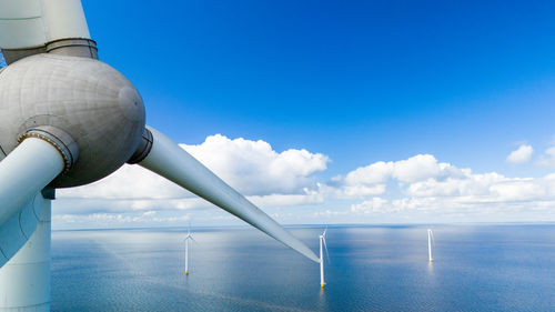 Low angle view of man standing by sea against sky