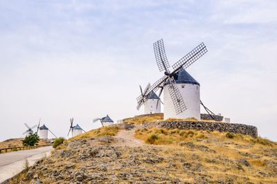 Traditional windmill on land against sky