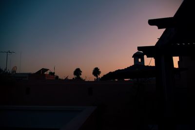 Silhouette buildings against sky at dusk