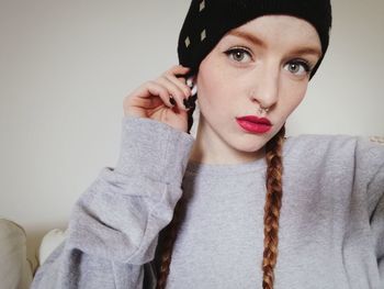 Portrait of young woman sitting on sofa at home