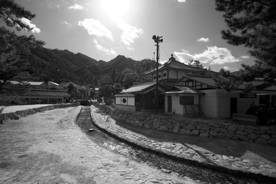 Houses by street and buildings against sky