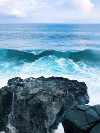 Scenic view of rocks in sea against sky