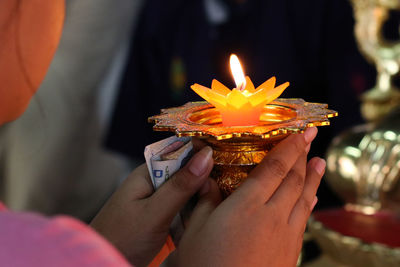 Close-up of woman holding illuminated flower