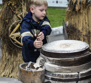 Boy grinding flour on millstones