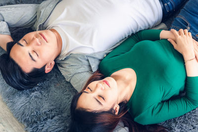 High angle view of couple relaxing on floor at home