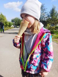 Portrait of little girl standing against trees