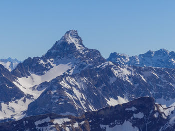 Scenic view of snowcapped mountains against clear sky