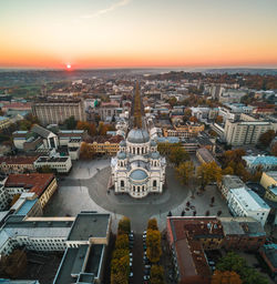 High angle view of city lit up at sunset