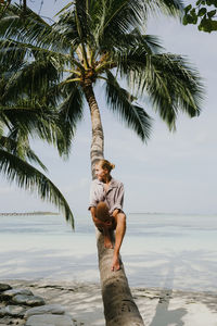 Woman sitting on the palm tree relaxing