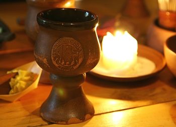 Close-up of lit candle on table at home