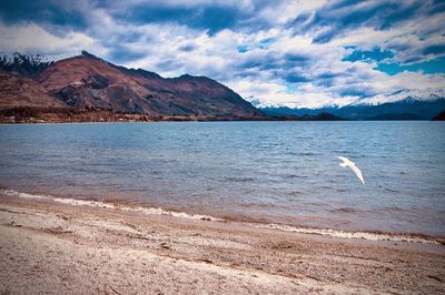 Scenic view of sea and mountains against sky