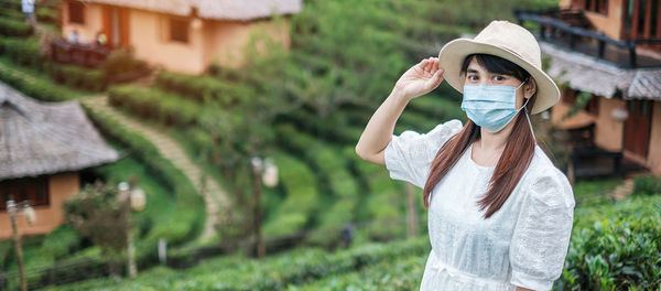 Full length portrait of woman standing by plants